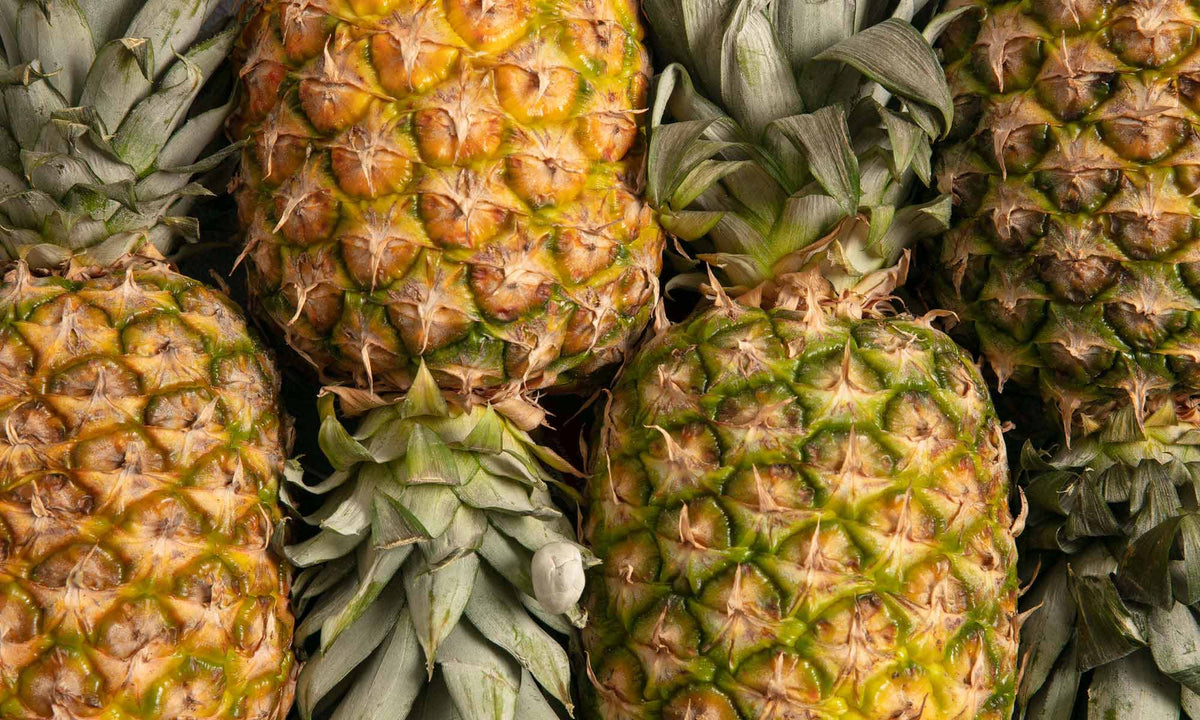 Mehrere frische Ananas Früchte nebeneinander liegend angeordnet