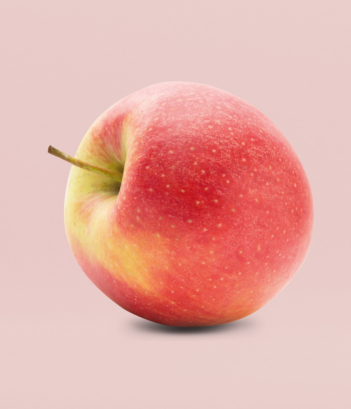 Frischer, knackiger roter Apfel vor rosa Hintergrund