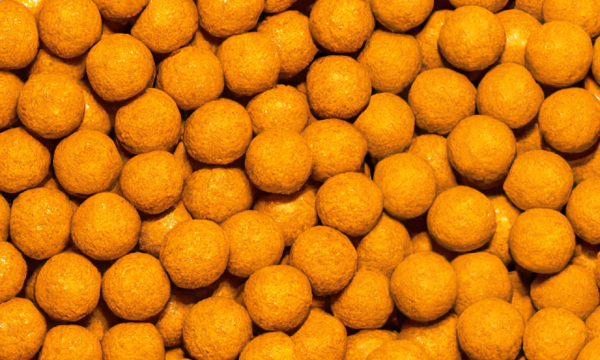 Viele kleine, runde, gelbe Ananas-Maracuja Kaubonbon von buah neben und aufeinander