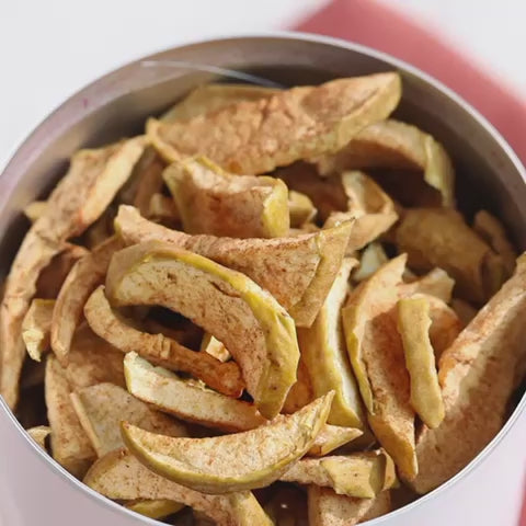Video einer Hand, die in einer Dose buah ApfelZimt greift und gefriergetrockneten Apfel heruasnimmt und ihn auf winterliche Pancakes legt als Topping